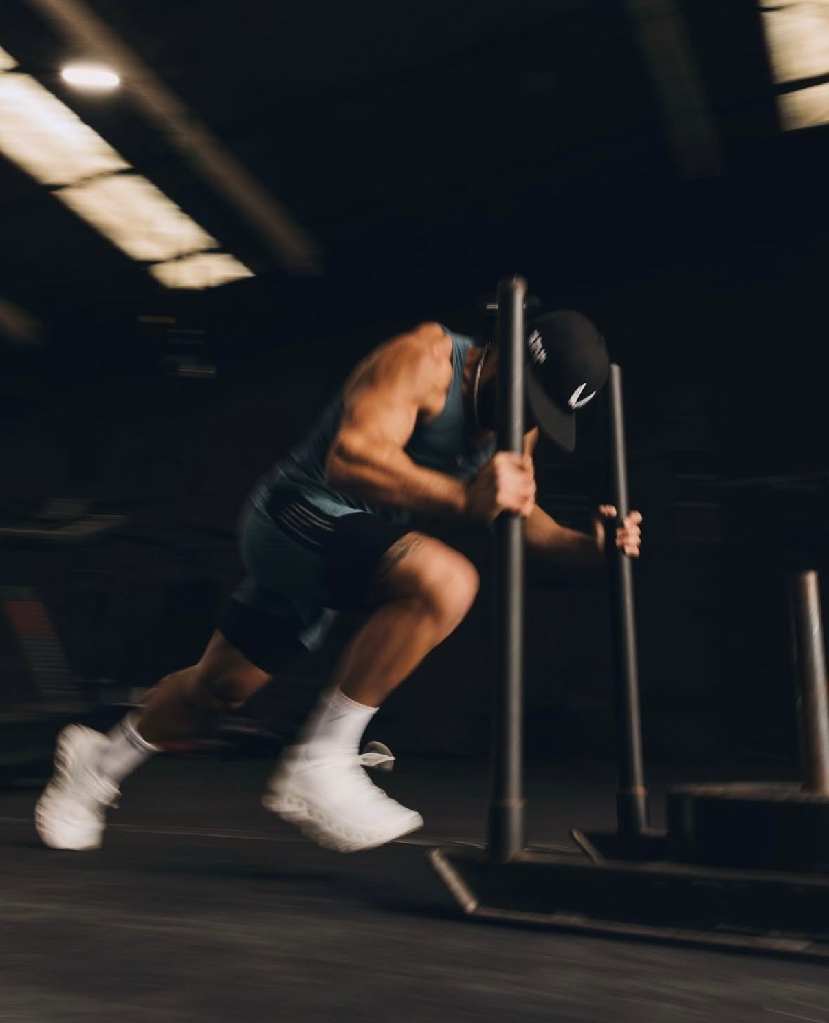 An athlete pushing a weighted sled across a training facility