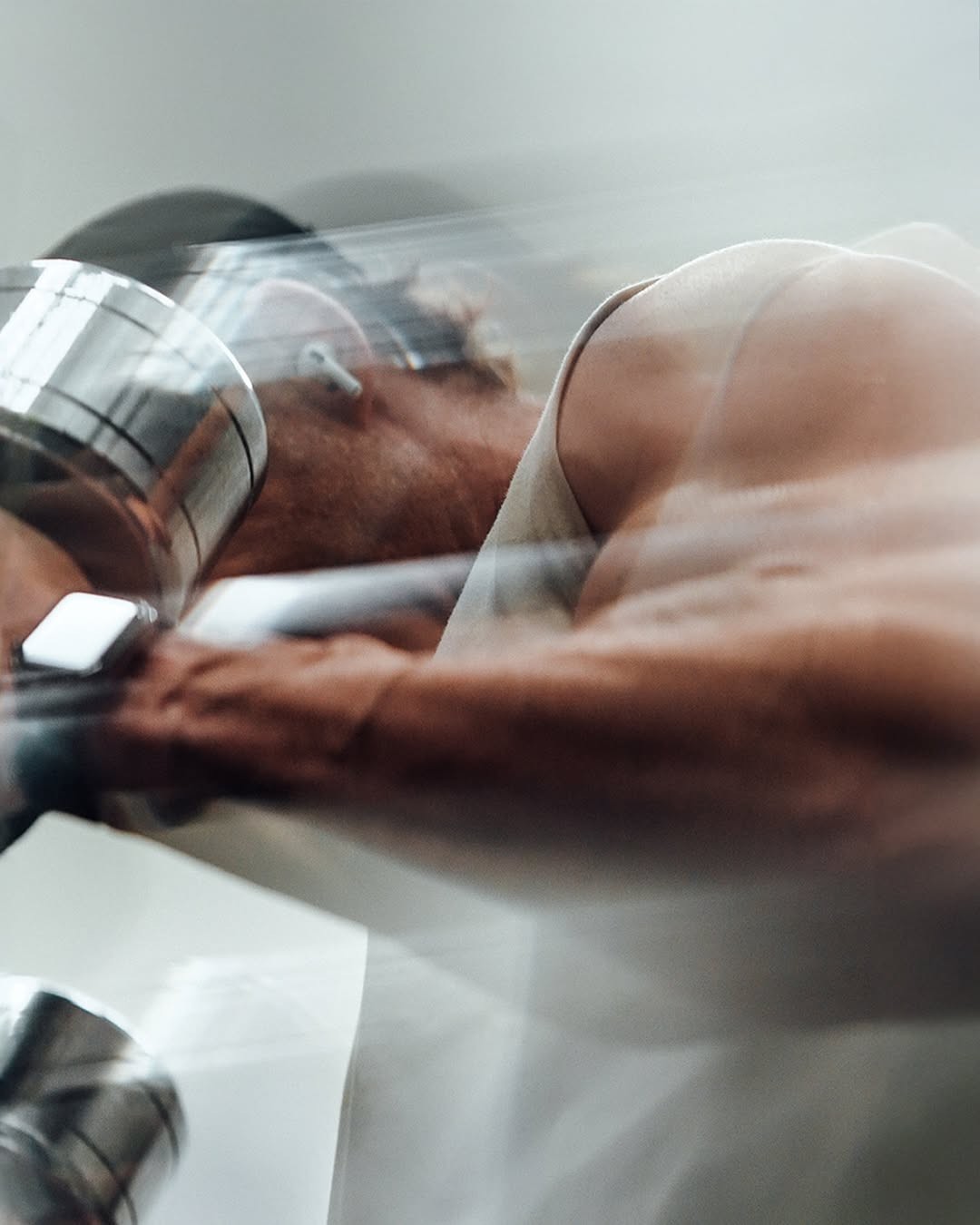 An athlete pressing a barbell overhead in a gym
